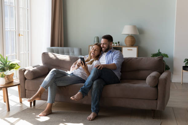 istock Couple relaxing on sofa spend time on internet using smartphone 1441252196