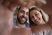 Beautiful couple showing heart shape to camera, close up shot
