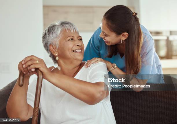 Happy Relax And Senior Woman With Caregiver Smile While Sitting On A Living Room Sofa In A Nursing Home Support Help And Professional Nurse Or Healthcare Worker Helping Elderly Lady Or Patient Stock Photo - Download Image Now