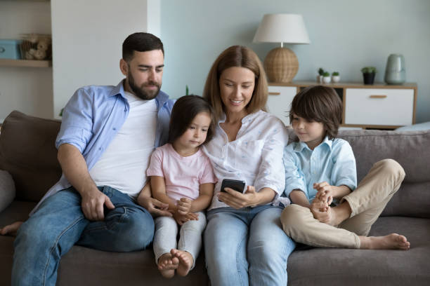 istock Couple and kids enjoy new mobile app using smartphone 1441253361