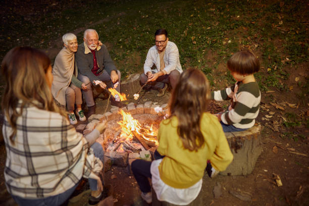 istock Happy multi-generation family roasting marshmallows on fire in nature. 1441253841