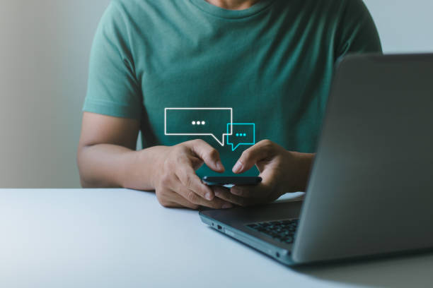 istock Social media marketing technology concept. Man hand using smartphone typing Live chat chatting and social network concepts, chatting conversation working at home in chat box icons pop up. 1441254789