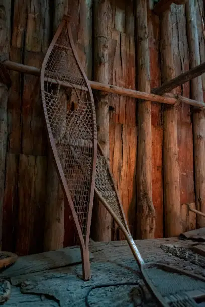 A pair of old Iroquois showshoes leans up against a wooden wall inside a longhouse at Crawford Lake near Milton, Ontario.
