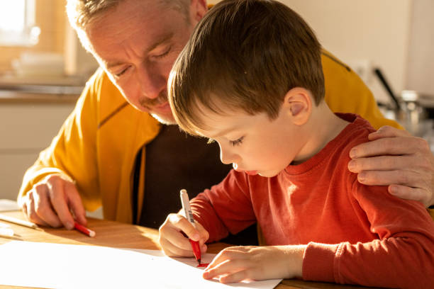 istock Father helps his 5 year old son learn to draw 1441261224