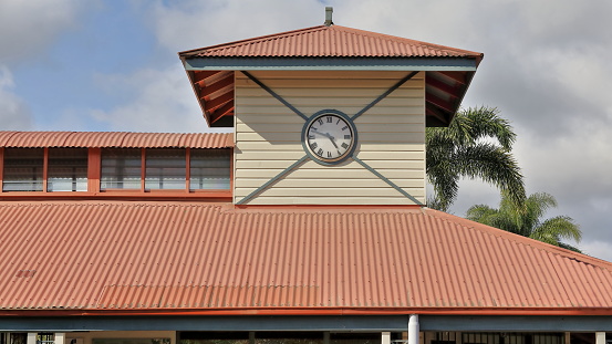 Clock tower on top of a heritage-style building in Centenary Park housing several facilities among them a public phone and the public toilet block. Kuranda-Queensland-Australia.