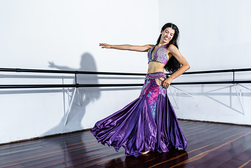 Young woman performing belly dance at dance school.
