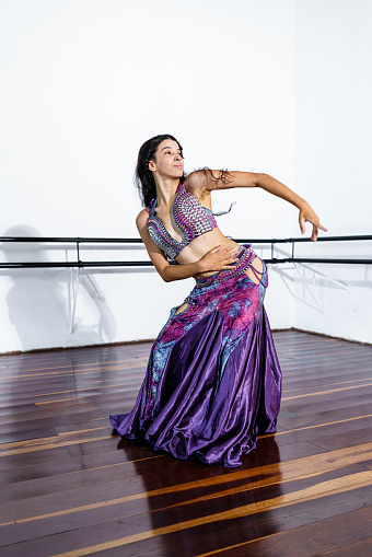 Young woman performing belly dance at dance school.