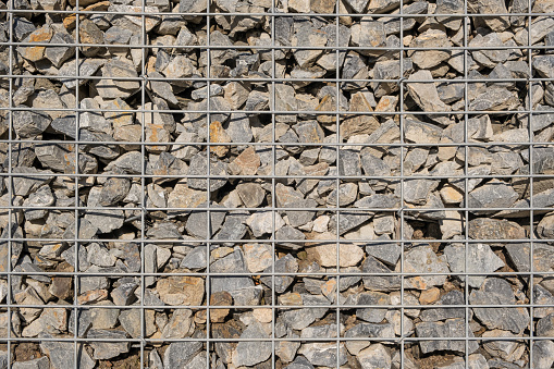 Granite stones in Gabion Wall in Wire Welded Mesh, Baskets, wire fence filled with stones background