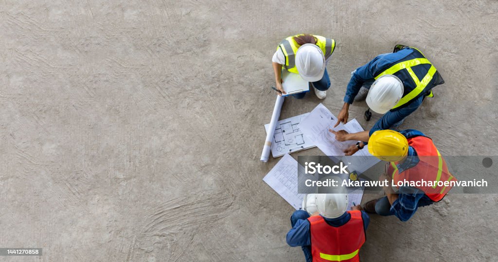 Top view of engineer, architect, contractor and foreman meeting at the construction building site with floor plan for real estate development project industry and housing timeline concept Top view of engineer, architect, contractor and foreman meeting at the construction building site with floor plan for real estate development project industry and housing timeline usage Construction Site Stock Photo