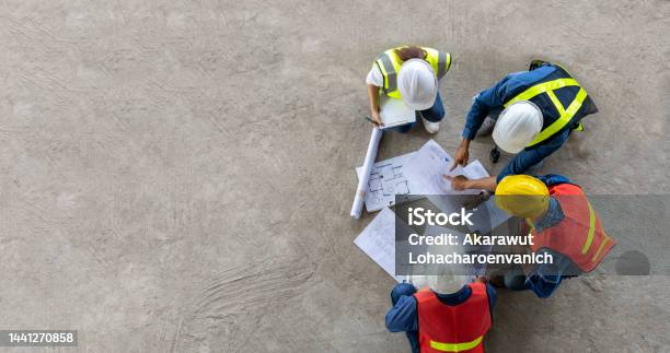 Top View Of Engineer Architect Contractor And Foreman Meeting At The Construction Building Site With Floor Plan For Real Estate Development Project Industry And Housing Timeline Concept Stock Photo - Download Image Now