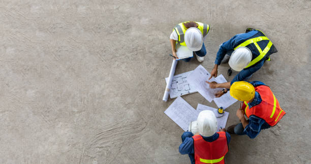 top view of engineer, architect, contractor and foreman meeting at the construction building site with floor plan for real estate development project industry and housing timeline concept - 建築物 個照片及圖片檔