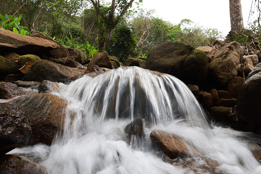 Close up water flow from stream canal, water flow in forest, natural background, rocks in creek or stream flowing water