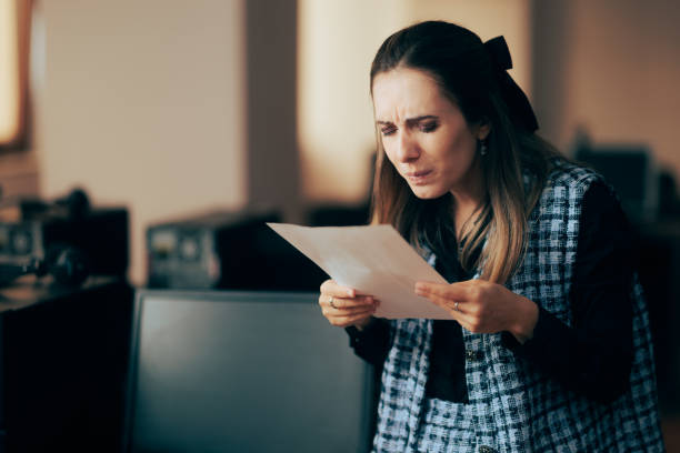 woman squinting trying to read the fine print on a contract - fine print imagens e fotografias de stock