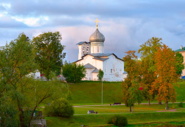 Old Russian temples of Pskov. The Church of the Epiphany of the XV century in a park on the river bank (untranslatable Old Slavonic text). Pskov, Russia, 2022