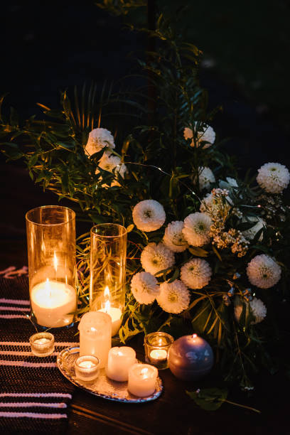 istock Romantic candlelight dinner at terrace restaurant at night. Location for surprise marriage proposal. A place for date or engagement in park in a tent and decorated with candles and garlands. Closeup. 1441284778
