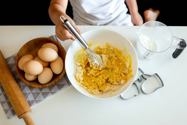 istock Child cook stirs dough for biscuits with a whisk 1441284784
