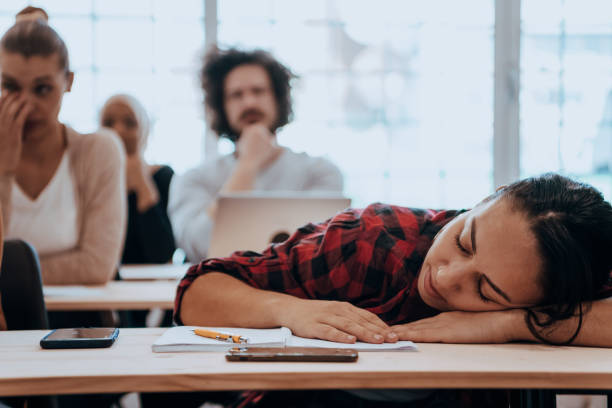 istock Tired woman napping on the table during a lecture in the classroom 1441286226