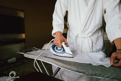 Businessman Ironing Shirt at Hotel Room
