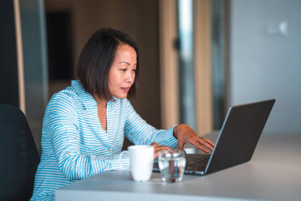 istock Good Looking Mature Asian Female Manager Working At Home 1441286744
