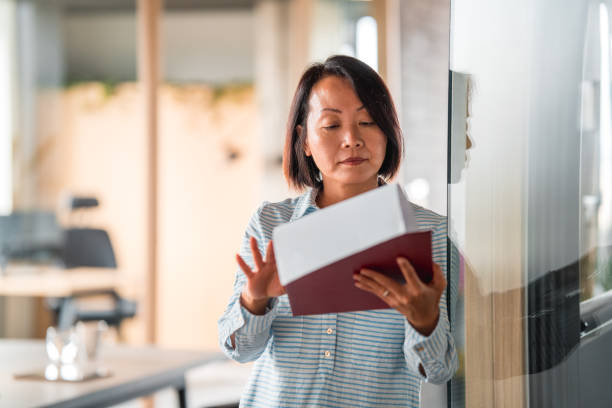 istock Mature Chinese Female Manager Reading Documents 1441286752
