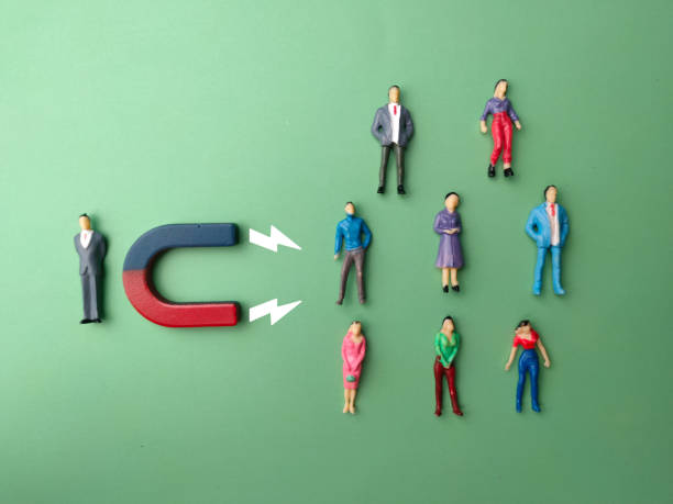 istock Top view miniature businessman attracts people using magnet. Business concept. 1441287010