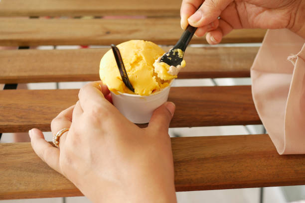 istock women eating mango vanila flavor ice cream in a container 1441289515