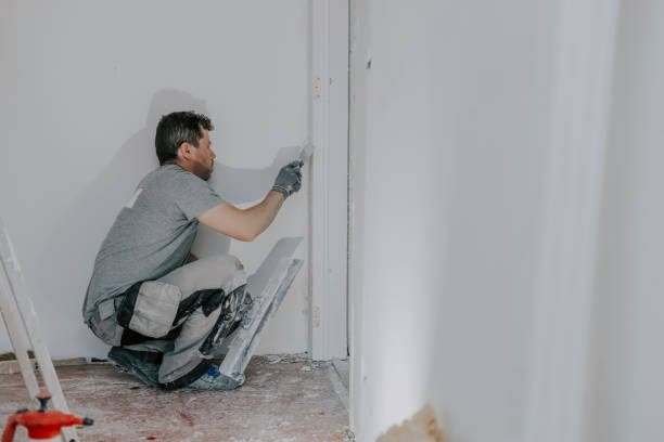 молодой строитель оштукатуривает дверной проем. - plasterer plaster wall dirty стоковые фото и изображения