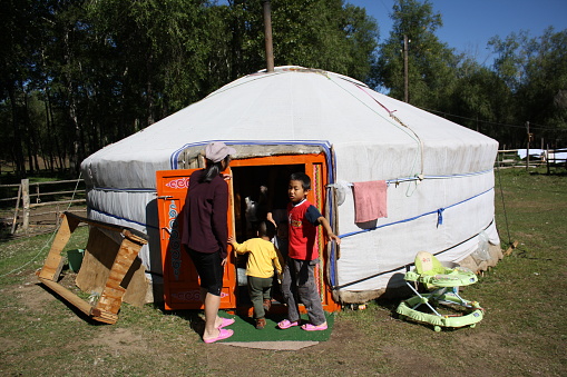 A family in the nomadic tent (ger) in Terelj valley, Tuv, Mongolia. Visiting a nomadic family in the lonely valley is precious. The local family joyfully welcomes with open arms.