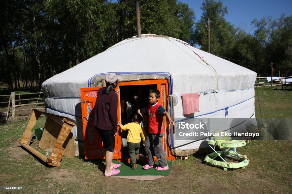 A family in the nomadic tent (ger) in Terelj valley, Tuv, Mongolia. A family in the nomadic tent (ger) in Terelj valley, Tuv, Mongolia. Visiting a nomadic family in the lonely valley is precious. The local family joyfully welcomes with open arms. Family Stock Photo
