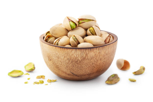 istock Pistachio nuts in shell in wooden bowl isolated on white background 1441307873