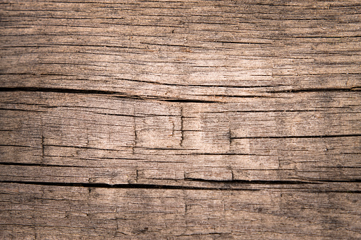 Beautiful aged wooden table close-up, top view. Natural wood background with cracks and texture