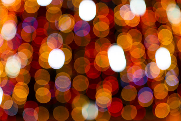 Beautiful bright multi-colored lights in the dark. Abstract festive background with defocus blurred circles