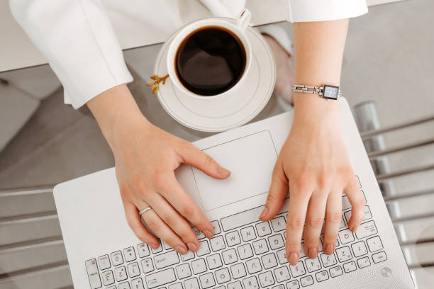 istock Female hands work on a modern laptop. Next to a cup of coffee 1441317933