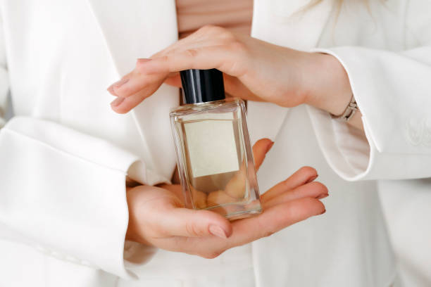 This image has an empty alt attribute; its file name is hands-of-a-beautiful-young-woman-with-a-bottle-of-floral-perfume.jpg