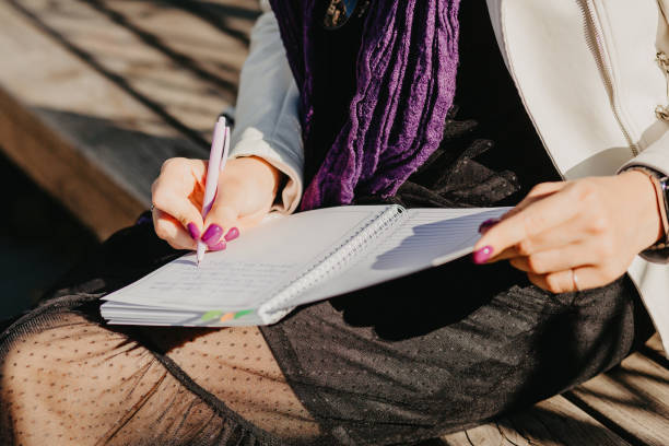 istock Young girl writes in a notebook with a pen 1441317961