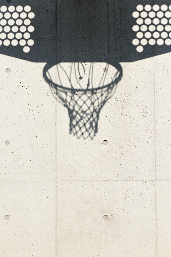 Close-up of Basketball hoop shadow on a white concrete wall with copy space.