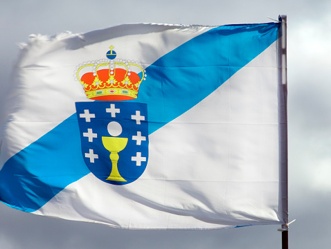 Galicia flag fluttering in the wind . Sky in the background. Santiago de Compostela, Galicia, Spain.