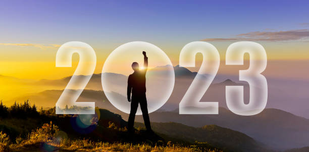 Silhouette d’homme levant les mains pour défier 2022 sur une colline de montagne. Bonne année 2023. Silhouette d’homme au coucher du soleil, lever du soleil lever la main pour combattre 2023 sur le changement de spectacle de montagne, startup, object - Photo