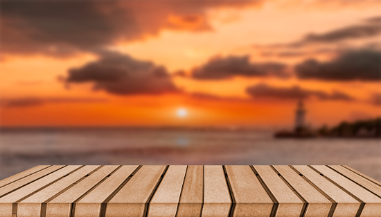 Wooden table top with beach sunset view in background.