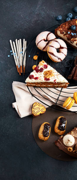 istock Table with various cookies, donuts, cakes, cheesecakes on dark background. 1441322777
