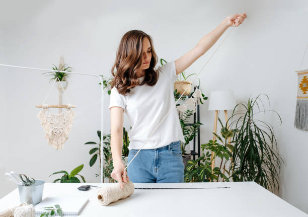 istock Young woman pulling on a rope, she is a macrame craftsman. 1441324711