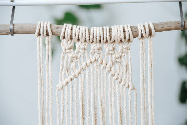 istock Suspended stick with macrame piece in progress, only partially weaved. 1441325881