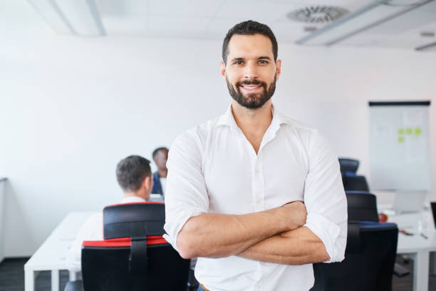 Handsome businessman standing at office. Portrait of smiling man employee in office stock photo
