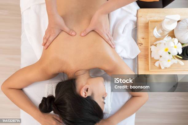 Hands Of Masseur Massaging Back Of Relaxed Woman With Aromatherapy Essential Oil On Massage Table Stock Photo - Download Image Now