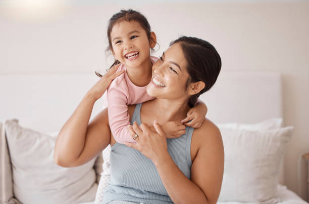 bedroom, happy and smile of mother and girl resting and spending time together on a holiday. relax, happiness and calm woman and her child sitting on a bed and hugging in a room of their family home. - dotter bildbanksfoton och bilder