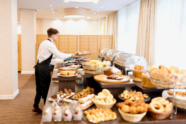 istock Waiter setting up food on a buffet table at hotel or restaurant 1441333626