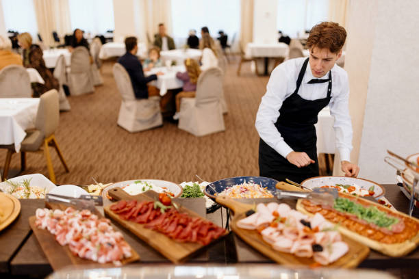 istock Waiter setting up food on a buffet table at hotel or restaurant 1441333683