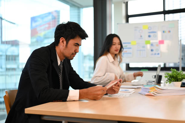 istock Focused businessman analyzing financial data, stock market information while sitting at meeting table. 1441334522