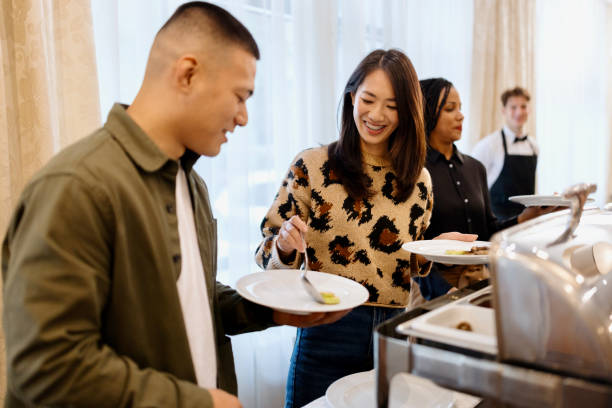 istock Couple choosing breakfast from buffet table at the hotel restaurant 1441334527