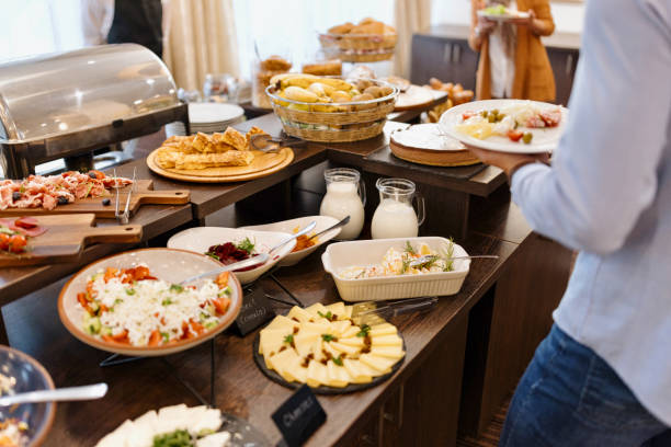 Food Buffet Catering Dining Eating Party Sharing Concept. Multi ethnic people group catering buffet food breakfast indoor in luxury hotel restaurant with meat colourful fruits and vegetables